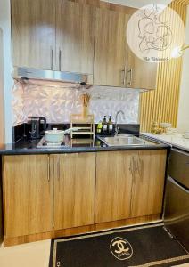 a kitchen with wooden cabinets and a sink at The Turianos in Manila +7 photos
