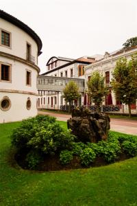a building with a rock in the middle of a yard at Blau Gran Hotel Las Caldas, a member of Radisson Individuals in Las Caldas