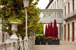 a street with plants and red umbrellas on a sidewalk at Blau Gran Hotel Las Caldas, a member of Radisson Individuals in Las Caldas