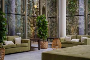 a living room with couches and tables and large windows at Blau Gran Hotel Las Caldas, a member of Radisson Individuals in Las Caldas +159 photos