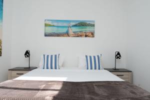 a bedroom with a bed with blue and white pillows at Villa Liana by LovelyStay in Ponta do Sol +35 photos