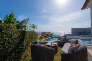 a patio with chairs and a swimming pool at Villa Liana by LovelyStay in Ponta do Sol