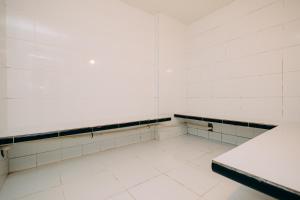 an empty gym room with white walls and white tiles at Eco Stay in Curitiba