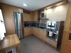 a kitchen with wooden cabinets and stainless steel appliances at Piso Rualte in Ávila +14 photos