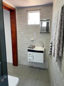 a bathroom with a sink and a window at Pousada aconchego in Imbituba +24 photos