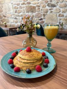 a plate with pancakes and berries on a table at Alojamento Dias in Tarouca