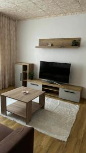 a living room with a coffee table and a flat screen tv at Sylvia Residence in Lupeni