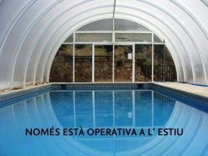 an indoor swimming pool with an archway and a swimming poolasteryasteryasteryastery at Hostal Les Fonts in Castellar de NʼHug