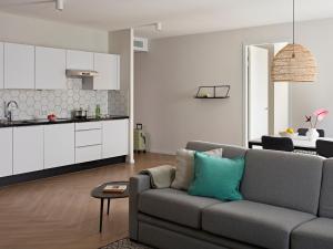a living room with a couch and a kitchen at Numa Amsterdam Docklands in Amsterdam