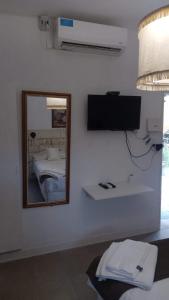 a mirror in a room with a bed and a television at Alojamiento San Nicolas in La Rioja