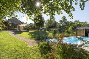a garden with a fence and a swimming pool at La Ressource in Cherain