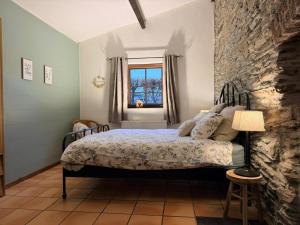 a bedroom with a bed and a stone wall at La Ressource in Cherain +12 photos