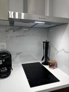 a kitchen with a counter top with a stove top oven at Appart'Hôtel 23 Le Cocon Creusois Studio in Guéret