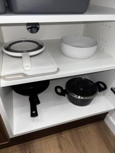 a shelf with two pans and bowls on it at Appart'Hôtel 23 Le Cocon Creusois Studio in Guéret