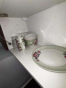 a white counter with a plate and two dishes on it at Appart'Hôtel 23 Le Cocon Creusois Studio in Guéret +5 photos