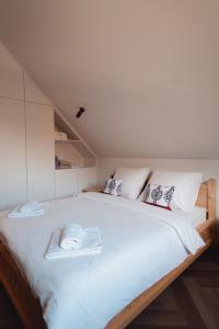 a bedroom with a large white bed with two towels on it at Muciówka in Jurków +60 photos