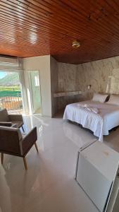 a bedroom with a bed and a chair and a table at Mirante Pai Inácio in Lençóis