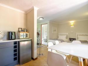 a kitchen and living room with a white table and chairs at The Horseshoe Guesthouse in Midrand +36 photos