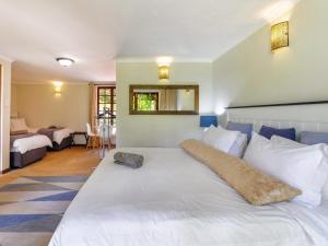 a bedroom with a large white bed with a long pillow at The Horseshoe Guesthouse in Midrand