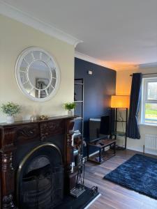 a living room with a fireplace and a mirror at StoneHaven Townhouse in Donegal
