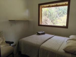 a bedroom with a bed with a window and a chair at rancho california rancho beira d'água Delfinopolis in Delfinópolis +57 photos