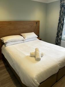 a large white bed with two towels on it at Hamilton House, Chester in Hope