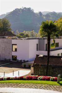 a white building with a palm tree in a courtyard at Blau Hotel Las Caldas, a member of Radisson Individuals in Las Caldas