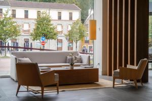 a living room with a couch and a table and chairs at Blau Hotel Las Caldas, a member of Radisson Individuals in Las Caldas