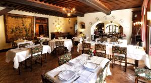 a restaurant with white tables and chairs in a room at Hostellerie du Vieux Pérouges in Pérouges
