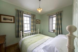 a bedroom with a bed and two windows at Tangle Tower in Inverness