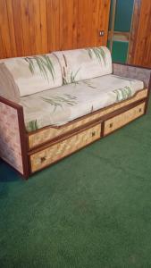 a bed with a wooden frame on a green floor at Casetta mia, Pian de Valli in Terminillo