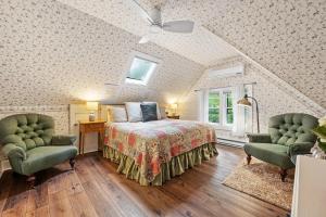 a bedroom with a bed and two chairs at Brook Farm Inn in Lenox +115 photos