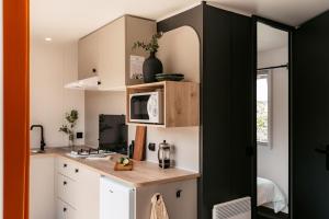 a small kitchen with a counter and a microwave at Camping Au Coeur de Vendome in Vendôme