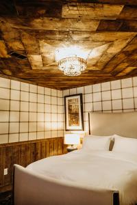 a bedroom with a white bed and a chandelier at Bootleggers Lodge on Lake Nokomis in Tomahawk +125 photos