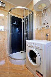 a washing machine in a bathroom with a shower at Apartman Promaja in Široki Brijeg +22 photos