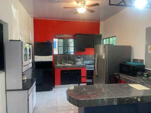 a large kitchen with black appliances and red walls at Evolution Home in Astoria