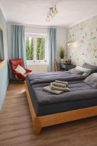 a bedroom with two beds and a red chair at Ferienwohnung Gartenglück im Mölltal in Semslach