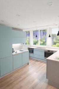 a large kitchen with white cabinets and windows at Ferienwohnung Gartenglück im Mölltal in Semslach