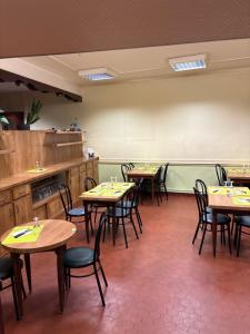 a dining room with tables and chairs in a restaurant at Hôtel café des cours in Cébazat +3 photos