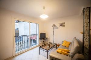 a living room with a couch and a balcony at T3 Cosy - Art Déco in Villefranche-de-Rouergue