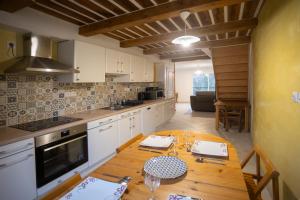 a kitchen with a wooden table and a dining room at T3 Cosy - Art Déco in Villefranche-de-Rouergue