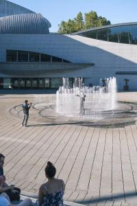 a man taking a picture of a fountain in front of a building at Romantic getaway with Balneo Centre Lorient in Lorient