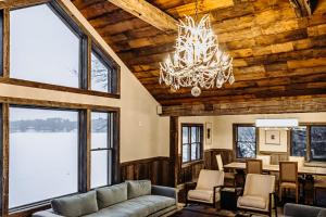 a living room with a couch and a chandelier at Bootleggers Lodge on Lake Nokomis in Tomahawk