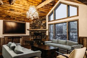 a living room with couches and a tv and a fireplace at Bootleggers Lodge on Lake Nokomis in Tomahawk