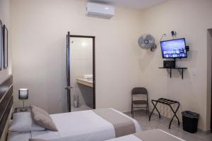 a bedroom with a bed and a tv and a fan at Casa 3 Torres, Calle 76 in Mérida