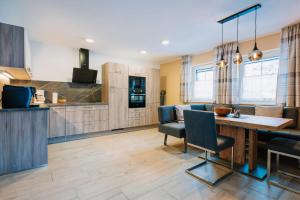 a kitchen and living room with a table and chairs at App. Marlos in Leisach