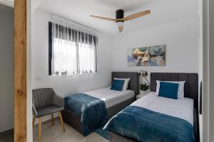 a bedroom with two beds and a chair at Iconic Sea View in Gran Alacant +27 photos