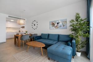 a living room with a blue couch and a table at Iconic Sea View in Gran Alacant