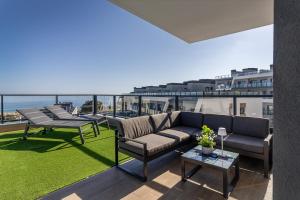 a living room with a couch and chairs on a balcony at Iconic Sea View in Gran Alacant