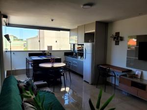 a kitchen and living room with a couch and a table at Flat Praia Itacoatiara in Niterói